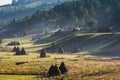 Beautiful rural mountain landscape in the morning light with fog, old houses and haystacks Royalty Free Stock Photo