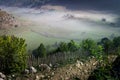 Beautiful rural mountain landscape in the morning light with fog, old houses and haystacks Royalty Free Stock Photo