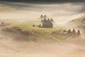 Beautiful rural mountain landscape in the morning light with fog, old houses and haystacks Royalty Free Stock Photo