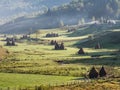 Beautiful rural mountain landscape in the morning light with fog,old houses and haystacks Royalty Free Stock Photo