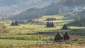 Beautiful rural mountain landscape in the morning light with fog,old houses and haystacks Royalty Free Stock Photo