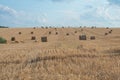 Beautiful rural Ukrainian landscape. Round bales of straw on harvested fields and a blue sky with clouds Royalty Free Stock Photo