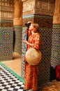 A beautiful Russian girl in a bright long dress in the palace of Fes takes pictures