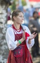 Beautiful Russian girl in a folk sundress claps her hands at a Slavic holiday