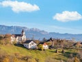 Beautiful rustic landscape in Magura village,Romania, with traditional romanian houses, a church and Piatra Craiului mountains in Royalty Free Stock Photo