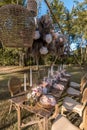 A beautiful rustic table setup at an outdoor garden wedding. White tall candles and pastel rose and tulip tabletop bouquet