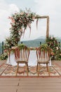 Beautiful rustic theme outdoor wedding white altar setup, with natural flower decoration and mountain background