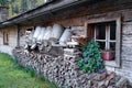 rustic wooden cabin with milk churns and a pile of firewood in front in Austrian Alps in the Gramai Alm region, Austria