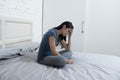 Beautiful sad and depressed Latin woman sitting on bed at home frustrated suffering depression Royalty Free Stock Photo