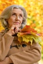 Beautiful sad elderly woman in autumn park Royalty Free Stock Photo