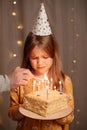 Sad girl with birthday cake. tradition to make wish and blow out fire Royalty Free Stock Photo