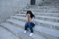 Beautiful and sad Hispanic woman desperate and depressed sitting on urban city street staircase