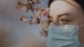 Beautiful sad woman in surgical face mask looks away. Eye close view Royalty Free Stock Photo