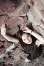 Beautiful sad young woman on a stone wall background