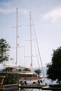 Beautiful sailing yacht stands in the harbor surrounded by green trees