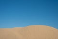 Beautiful sand dunes against bright blue sky background. Royalty Free Stock Photo