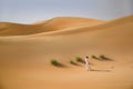 Beautiful sand dunes, grass and a slim running woman in white dress Royalty Free Stock Photo