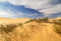 Beautiful sand dunes with sand pattern. Dunes landscape under blue sky with white clouds. Royalty Free Stock Photo