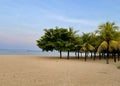 Beautiful sandy beach with clear blue skies. Palm trees can be seen in a cluster on the right. Shot in Bali, Indonesia. Royalty Free Stock Photo