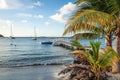 Beautiful sandy beach with palm trees and pier with boats and yachts at Anse a lÃ¢â¬â¢Ane beach, Martinique island, Caribbean sea, Royalty Free Stock Photo