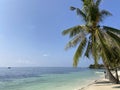 A beautiful sandy beach with palm trees on which coconuts grow.Boats in a sea of blue and turquoise background sky. Royalty Free Stock Photo