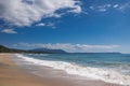 Beautiful sandy beach, sea waves, foam, blue sky, white clouds. Royalty Free Stock Photo