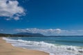 Beautiful sandy beach, sea waves, foam, blue sky, white clouds. Royalty Free Stock Photo