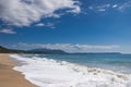 Beautiful sandy beach, sea waves, foam, blue sky, white clouds. Royalty Free Stock Photo