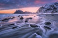 Beautiful sandy beach with stones in blurred water at sunset