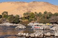Beautiful sandy landmark of faluca traditional boat sailing in the Nile river bank with vegetation and sand mountains Royalty Free Stock Photo