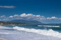 Sea waves and white foam in paradise sandy beach, blue sky, white clouds, sun, summer, wind. Royalty Free Stock Photo