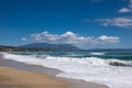 Sea waves and white foam in paradise sandy beach, blue sky, white clouds. Royalty Free Stock Photo