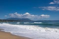 Sea waves and white foam in paradise sandy beach, blue sky, white clouds. Royalty Free Stock Photo