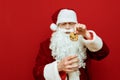 Beautiful Santa eating cookies and milk on a red background, puts cookies in glass. Christmas and New Year concept. Santa Claus Royalty Free Stock Photo