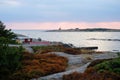 Beautiful scandinavian landscape with stones and moss. Traditional red swedish houses. Sea at sunset, the lighthouse on Royalty Free Stock Photo