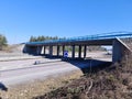 Beautiful scandinavian landscape view. Highway with speeding cars on green forest trees and blue sky background.