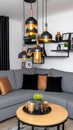 This beautiful Scandinavian living room features a grey sofa, eye-catching copper pendant lights, and elegant decor that