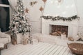 Beautiful Scandinavian new year`s interior. Christmas tree near the fireplace. Gifts under the Christmas tree