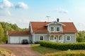 Beautiful scandinavian style house with two places garage and gar in fron of it. Summer with blue scky and green grass Royalty Free Stock Photo