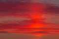 Beautiful scarlet sunrise behind the clouds