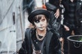 Beautiful scary little girl celebrating halloween. Terrifying black, white half-face makeup and witch costume