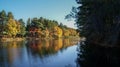 Beautiful scene of the colorful foliage of the trees in autumn fall season reflection in the black water river Royalty Free Stock Photo