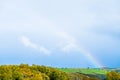 Beautiful scene of nature with a rainbow over a green field. I Royalty Free Stock Photo