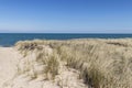 Beautiful Scene Of Sand Dunes Covered With Beach Grass Overlooking Lake Michigan With Blue Water And Blue Skies.