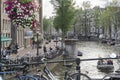 Beautiful scene of vintage bike laying down toa amstel river canal metal fence with amsterdam antique houses
