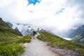 Beautiful scene of walking way with traveller among the green nature and rocky mountain with glacier over the Mt Cook National Royalty Free Stock Photo