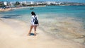 Beautiful scene of a woman walking on ocean beach. Young barefoot girl along the surf line Royalty Free Stock Photo