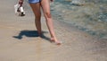 Beautiful scene of a woman walking on ocean beach. Young barefoot girl along the surf line Royalty Free Stock Photo