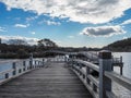 Beautiful scene of wooden bridge over the small river on blue sky with clouds background Royalty Free Stock Photo