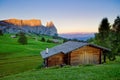 Beautiful Scenery from Alpe di Siusi, Italy in summer sunrise light with small wooden cottage and sharp mountains of dolomite. Royalty Free Stock Photo